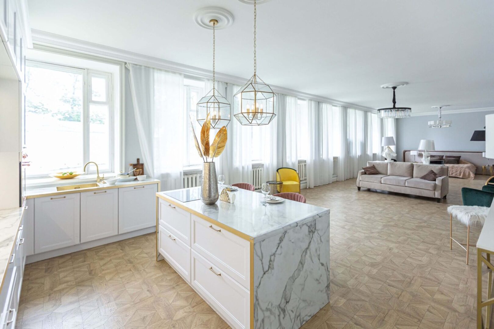 A kitchen with marble counter tops and white walls.