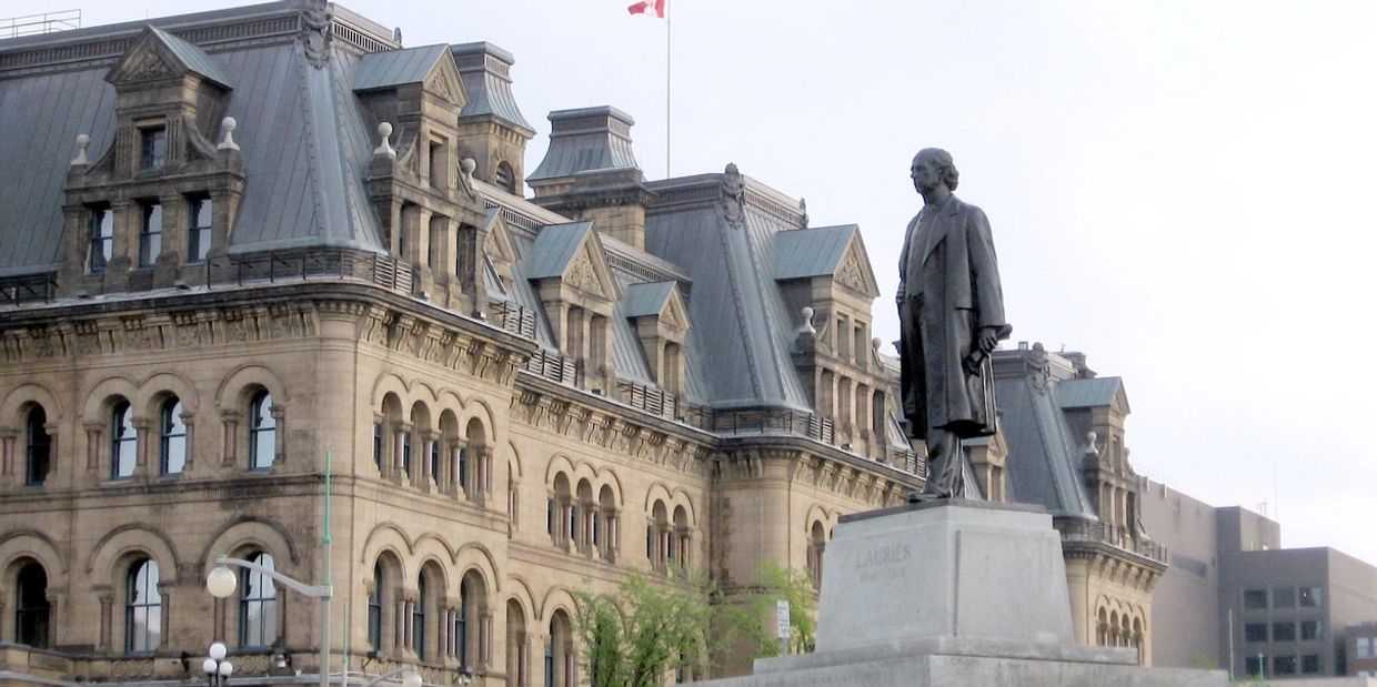 A statue of a man in front of an old building.